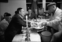 The ceremonial washing of hands. Natan Cywiak, shamus, at Passover Seder held in Warsaw's kosher kitchen. Holding cup and basin is Solomon Klingkoffer. 1979