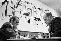 Chess players at the Jewish Club in Lodz. At the outbreak of WW II, one-third (230,000) of the city's residents were Jewish.  In 1975 approximately 500 remained, some gathering here to socialize. The mural, completed in 1960, by Adam (Aron) Muszka, is meant to depict the Holocaust. 1975 