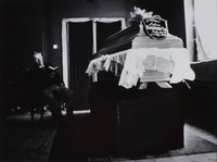 Pincus Szenicer, caretaker of Warsaw's Jewish Cemetery, reciting psalms for a recently deceased woman.  She was 74.