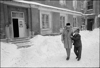Natan Cywiak (r) with a congregational member, sharing a joke after Shabbat services in Warsaw's Beit Midrash (doorway left). 1979