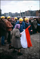 Woman carrying Polish flag arriving early for dedication ceremony of the Monument for the Fallen of 1970, Gdansk, Poland, Dec 1980