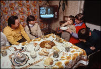 Gdansk shipyard worker Marian Mocko and family at dinner with TV news (Soviet Union leader Leonid Brezhnev pictured on tube), in their apartment, Gdansk, Poland, December 1980