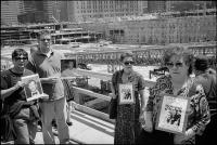Family members of those killed holding pictures of their loved ones on the morning of the first ceremony at WTC / Ground Zero marking the official completion of separation of human remains from 1.8 million tons of debris and removal of both, NY, NY, May 30, 2002